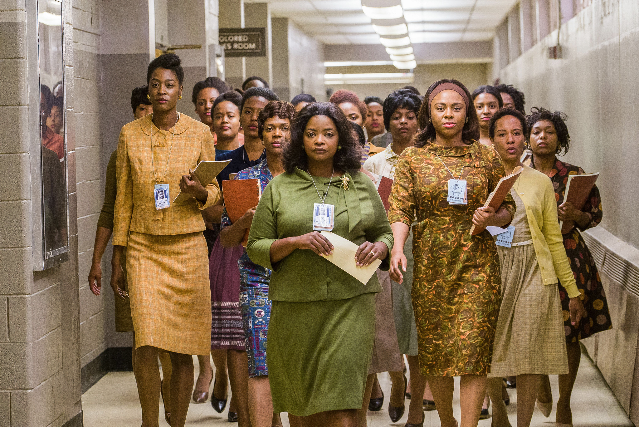Still frame from the film 'Hidden Figures': A group of Black female scientists walk confidently through the halls of NASA.