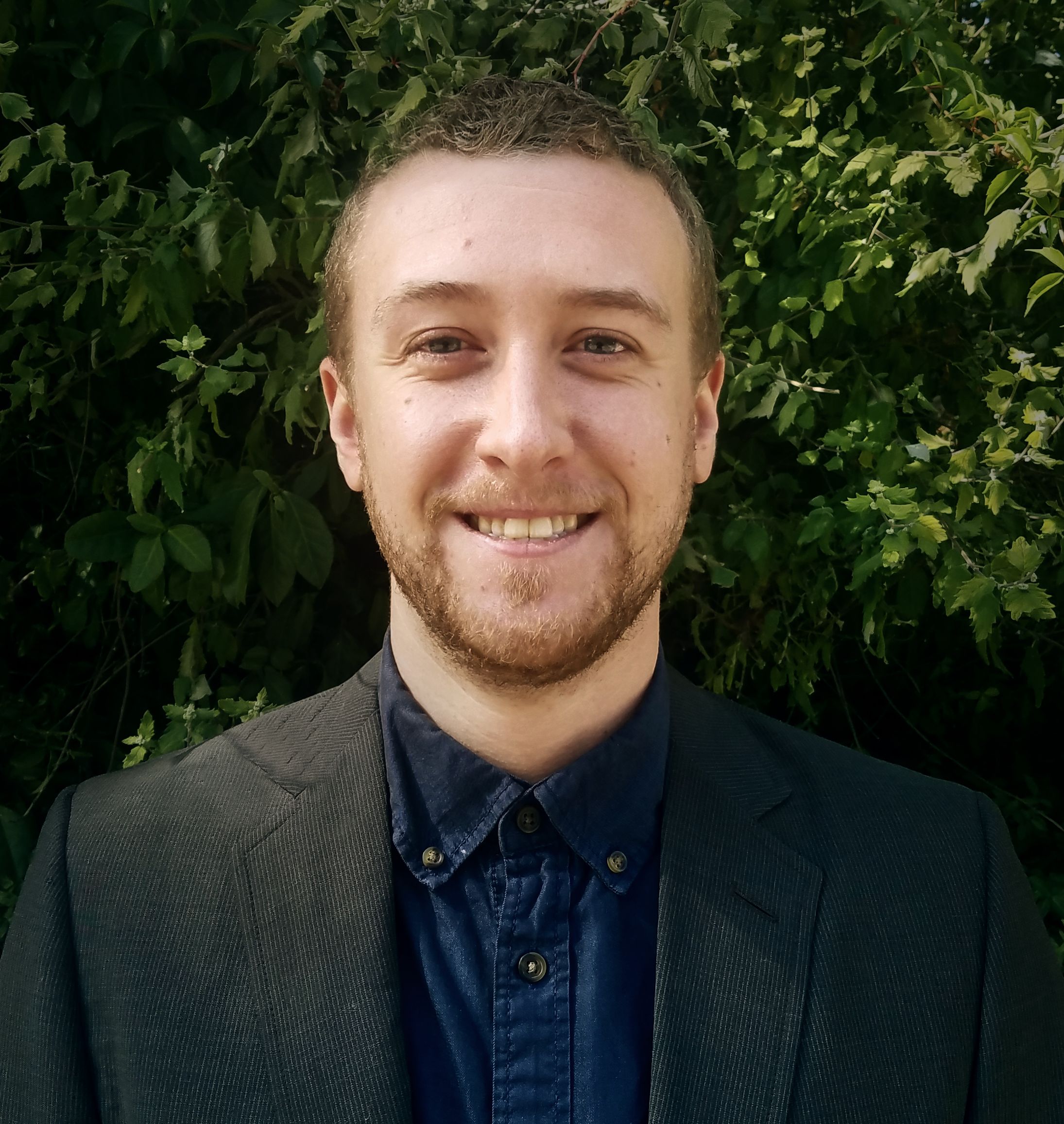 Man with beard smiling in outdoor setting