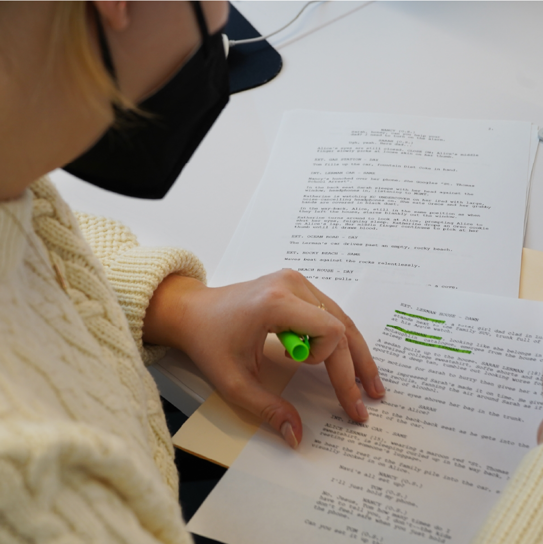 a young woman highlighting parts of a script