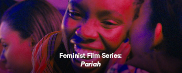 Screenshot from Pariah: It depicts the film's protagonist smiling, bathed in red light