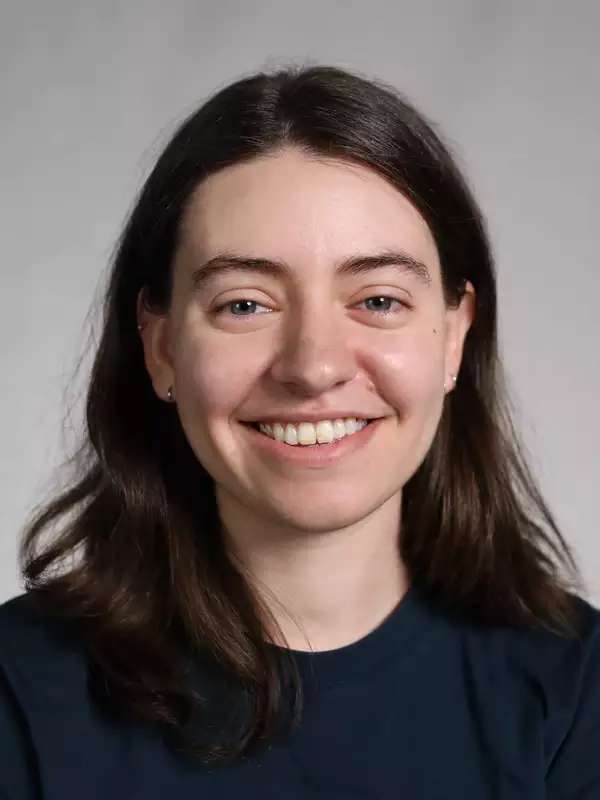 A white woman with short hair and dark t-shirt.